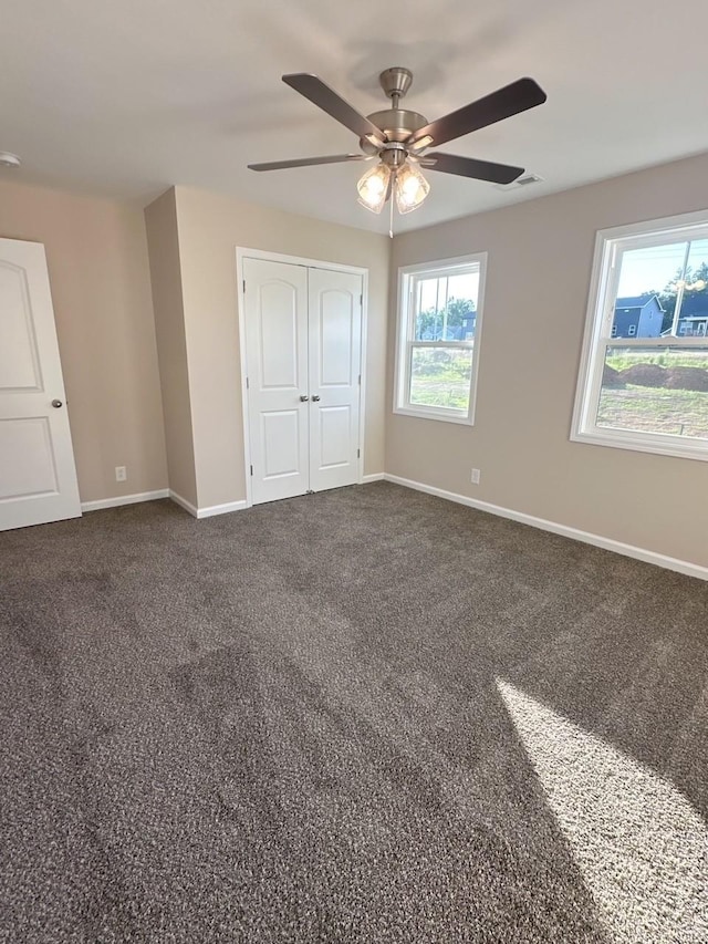 unfurnished bedroom featuring carpet flooring, ceiling fan, and a closet