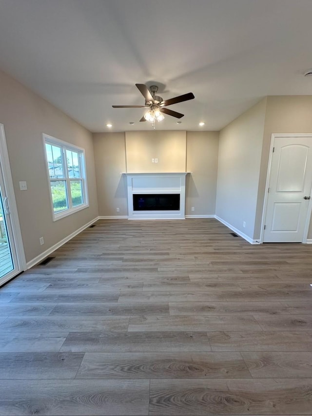 unfurnished living room with ceiling fan and light wood-type flooring