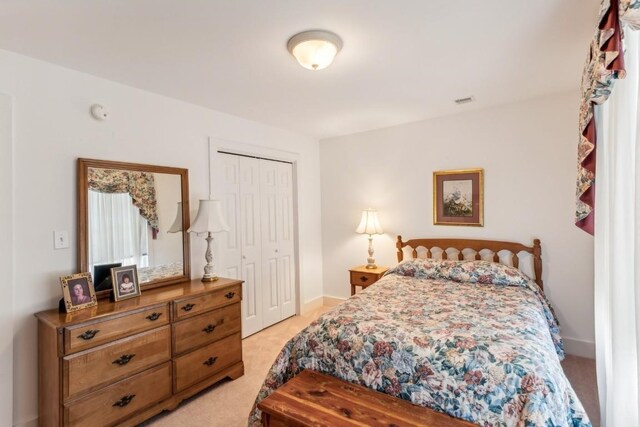 bedroom with a closet and light colored carpet