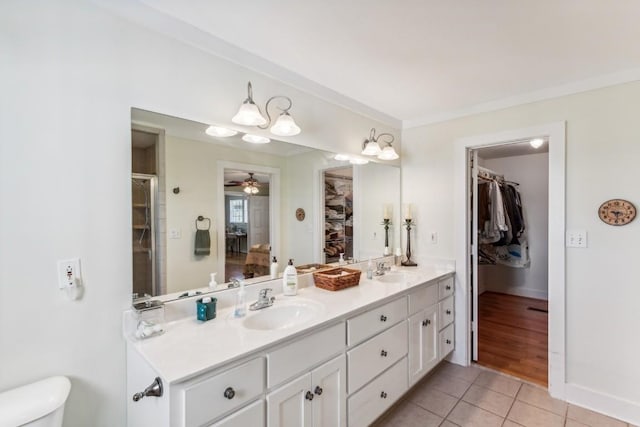 bathroom with vanity, tile patterned flooring, ceiling fan, ornamental molding, and walk in shower