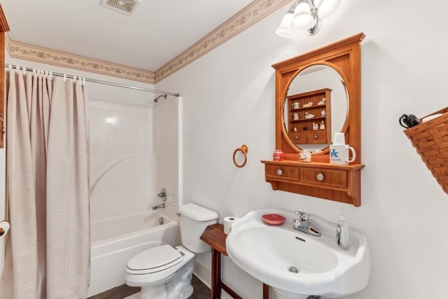 full bathroom featuring sink, shower / bath combination with curtain, and toilet