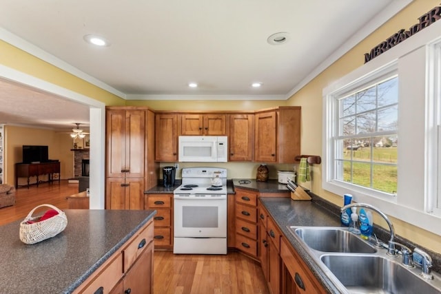 kitchen featuring white appliances, ceiling fan, crown molding, sink, and light hardwood / wood-style floors