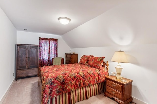 bedroom featuring light colored carpet and lofted ceiling