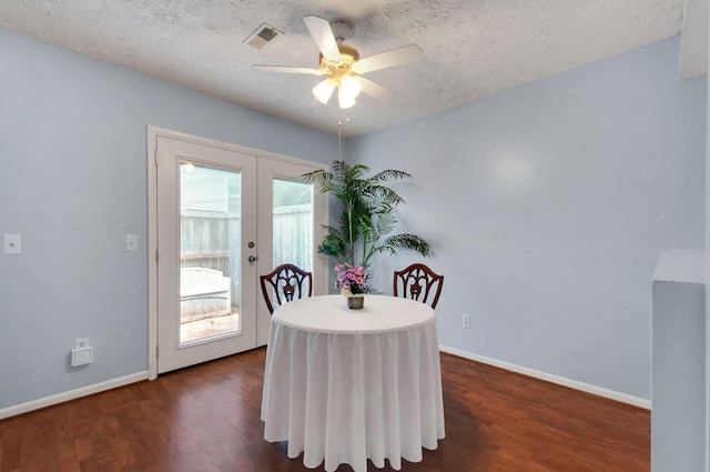 dining room featuring dark hardwood / wood-style flooring, ceiling fan, french doors, and a textured ceiling