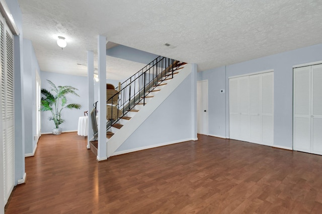 entrance foyer with a textured ceiling and dark wood-type flooring