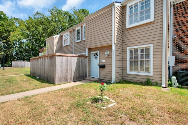 view of front of house featuring central air condition unit and a front lawn