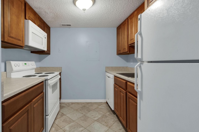 kitchen with a textured ceiling, sink, and white appliances