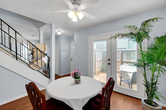 dining area with hardwood / wood-style flooring, ceiling fan, and a textured ceiling