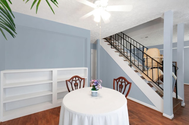 dining space with ceiling fan, dark hardwood / wood-style flooring, and a textured ceiling