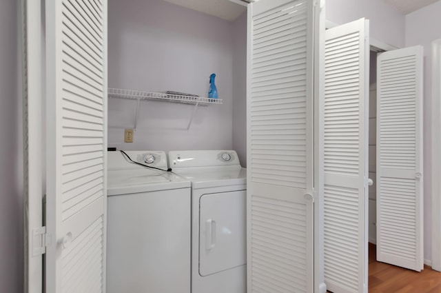 clothes washing area with light wood-type flooring and independent washer and dryer