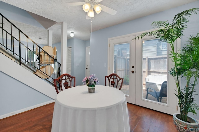 dining space featuring dark hardwood / wood-style flooring, a textured ceiling, french doors, and ceiling fan