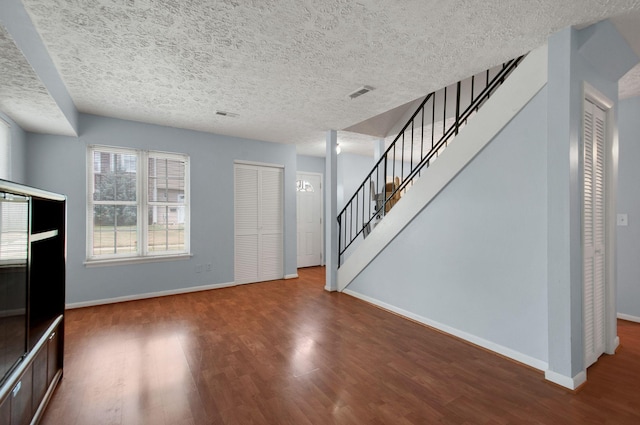 unfurnished living room with a textured ceiling and hardwood / wood-style flooring