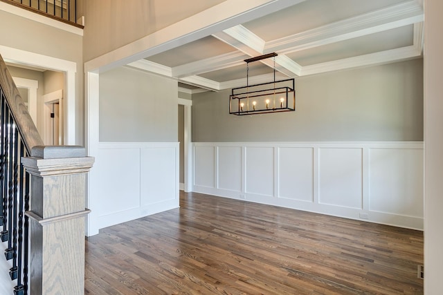 interior space with dark hardwood / wood-style flooring, ornamental molding, coffered ceiling, beamed ceiling, and a chandelier