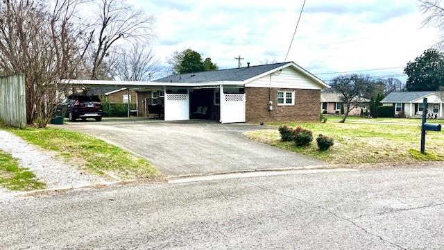 view of front of property featuring a carport and a front yard