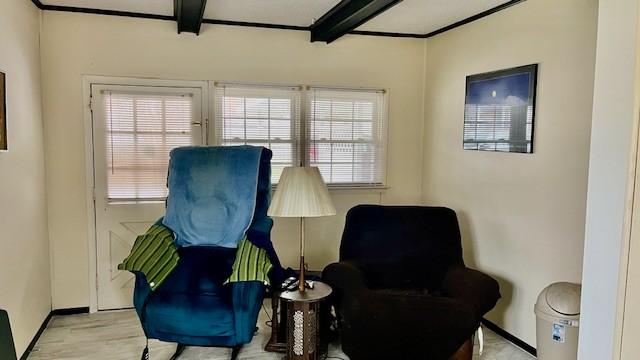 living area featuring beamed ceiling and light hardwood / wood-style floors