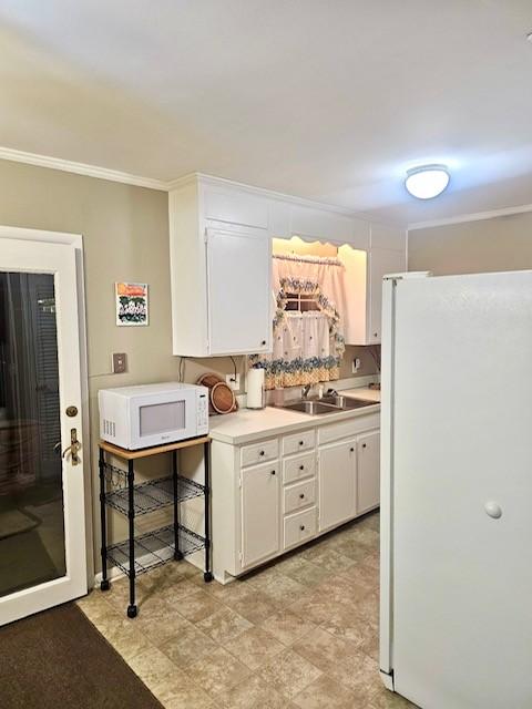 kitchen featuring white cabinetry, sink, white appliances, and ornamental molding