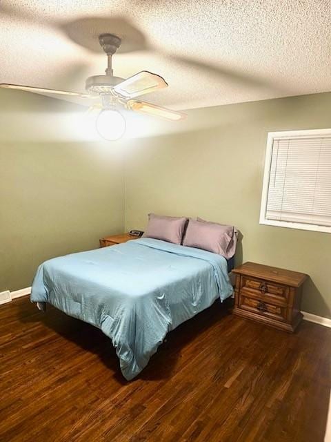 bedroom featuring ceiling fan, dark hardwood / wood-style floors, and a textured ceiling