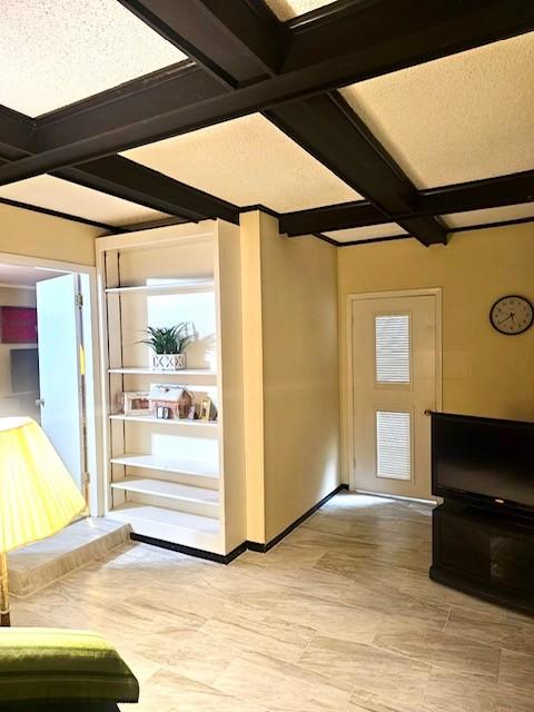 interior space with beam ceiling, light wood-type flooring, and coffered ceiling