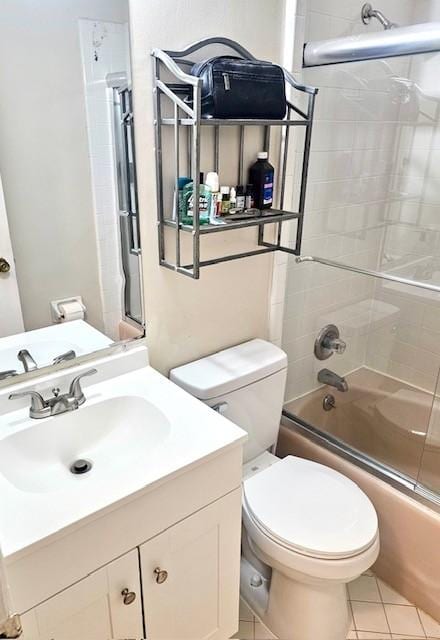 full bathroom featuring tile patterned floors, vanity, toilet, and shower / bath combination with glass door