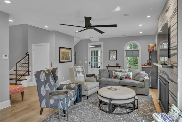 living room with ceiling fan and light hardwood / wood-style flooring