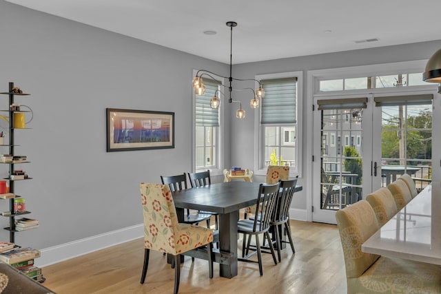 dining space featuring french doors and light wood-type flooring