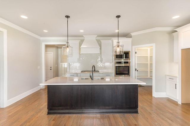 kitchen with custom exhaust hood, white cabinetry, a kitchen island with sink, and appliances with stainless steel finishes