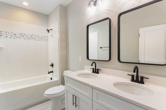 full bathroom featuring vanity, hardwood / wood-style floors, tiled shower / bath combo, and toilet