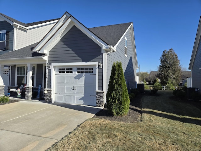 view of front facade with a garage, a front lawn, and central air condition unit