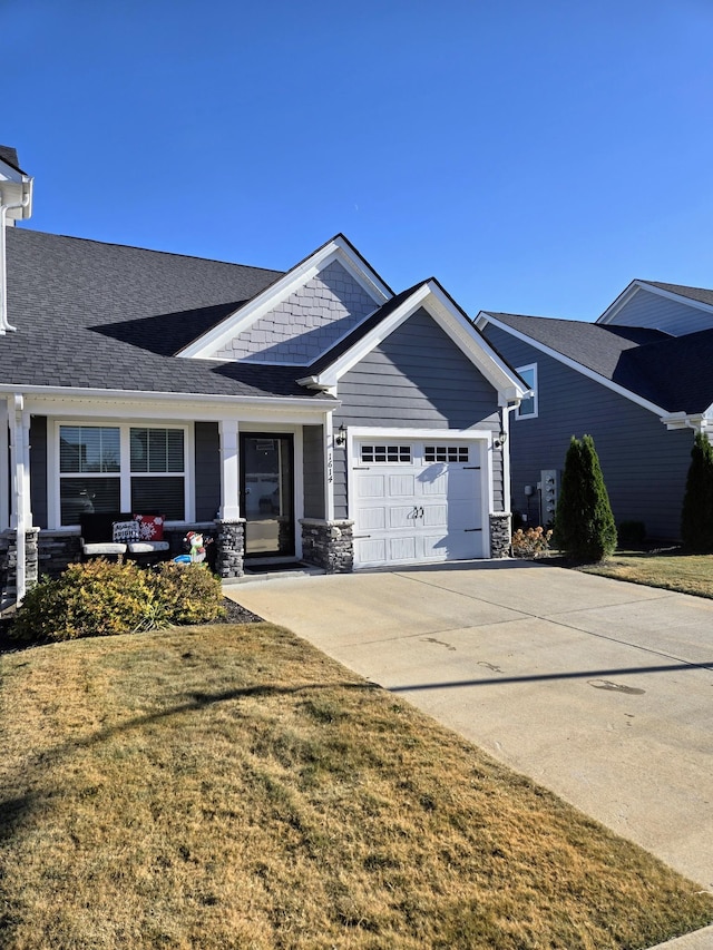 craftsman-style home with a front yard, a porch, and a garage