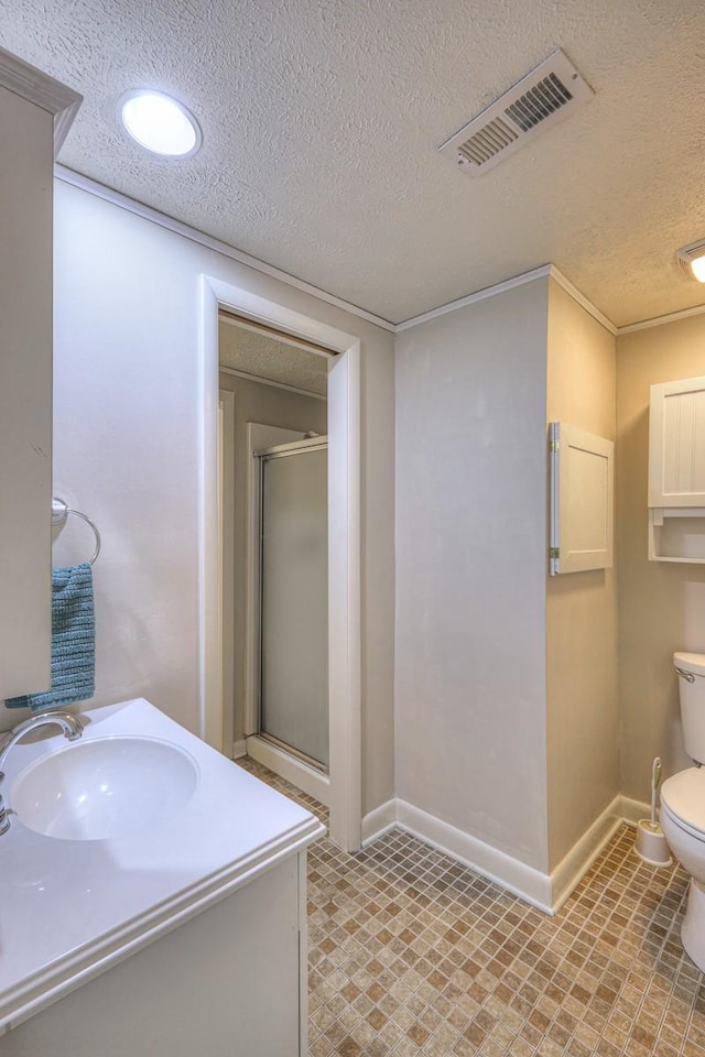 bathroom featuring toilet, vanity, a textured ceiling, and a shower with shower door