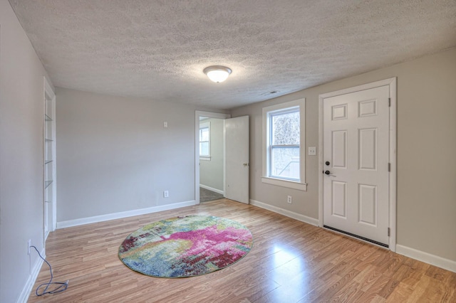 entryway featuring a textured ceiling and light hardwood / wood-style flooring