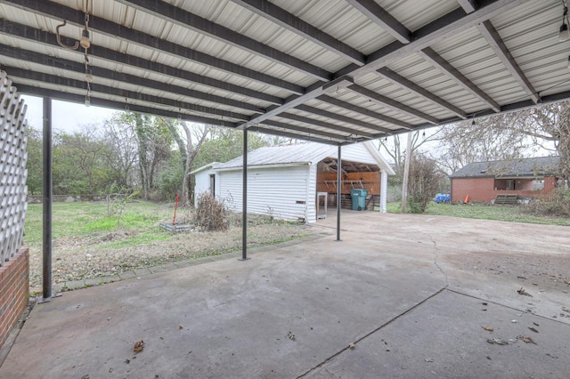 view of patio / terrace with a carport and an outbuilding