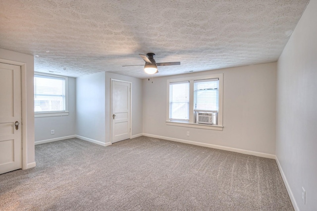 carpeted empty room with cooling unit, a textured ceiling, and ceiling fan