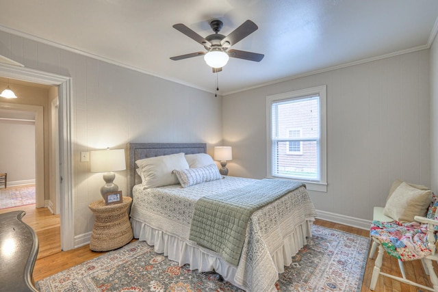 bedroom with ceiling fan, wood-type flooring, and ornamental molding