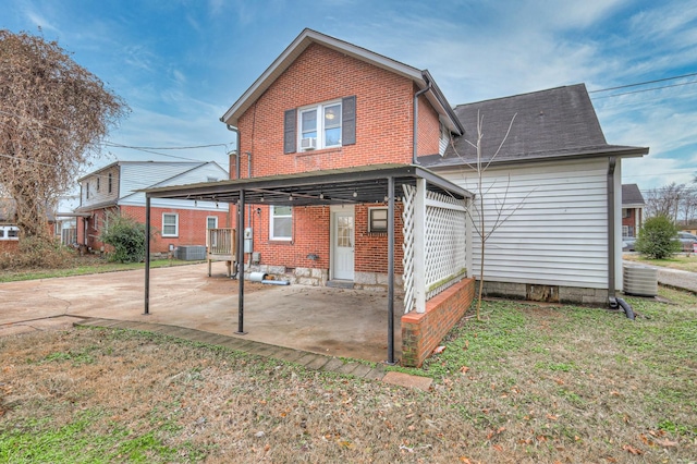 back of house featuring central AC and a carport