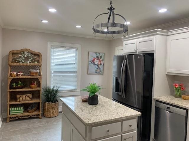 kitchen featuring white cabinetry, stainless steel appliances, light stone countertops, ornamental molding, and a kitchen island