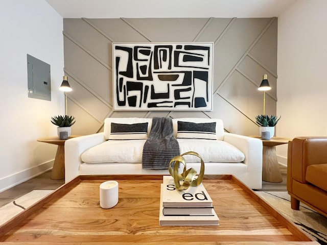 sitting room with electric panel and hardwood / wood-style flooring