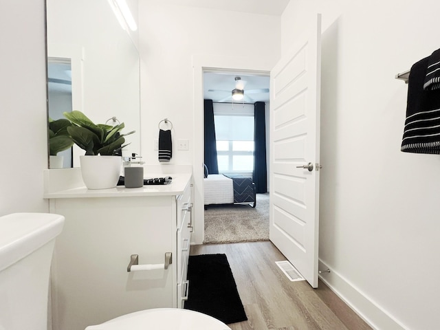 bathroom featuring vanity, wood-type flooring, and toilet