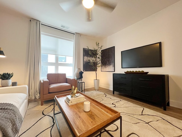 living room featuring light hardwood / wood-style flooring and ceiling fan