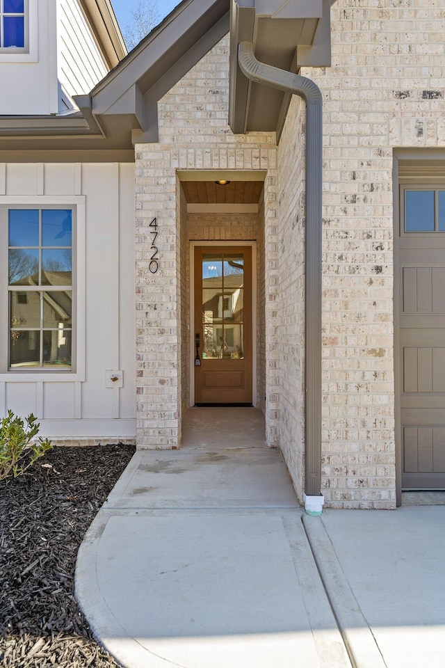 doorway to property featuring brick siding