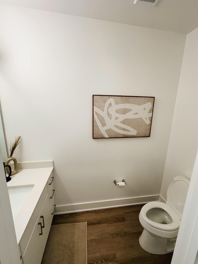 bathroom featuring hardwood / wood-style flooring, vanity, and toilet