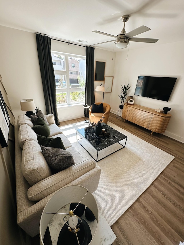 living room featuring hardwood / wood-style floors and ceiling fan