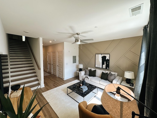 living room featuring ceiling fan, wood-type flooring, and electric panel