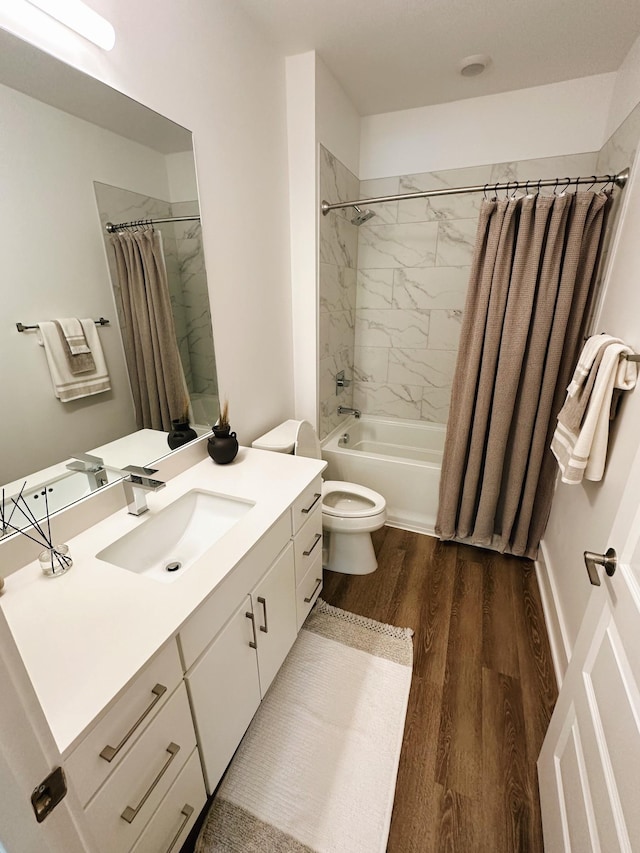 full bathroom featuring wood-type flooring, vanity, shower / tub combo, and toilet