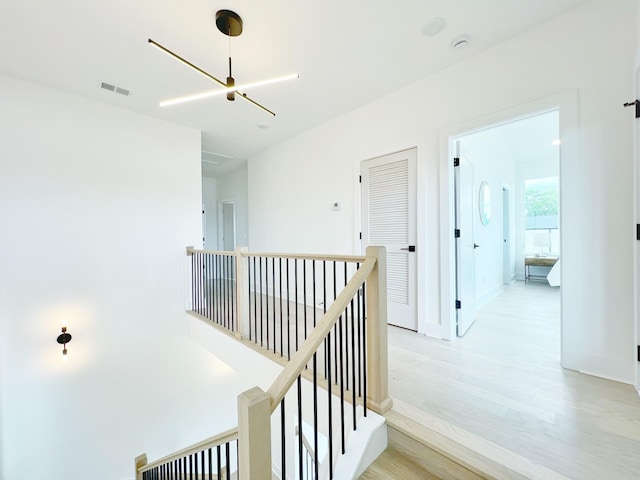 corridor featuring a chandelier and light wood-type flooring