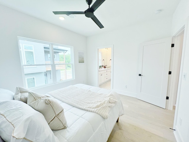 bedroom with ensuite bath, ceiling fan, and light hardwood / wood-style flooring