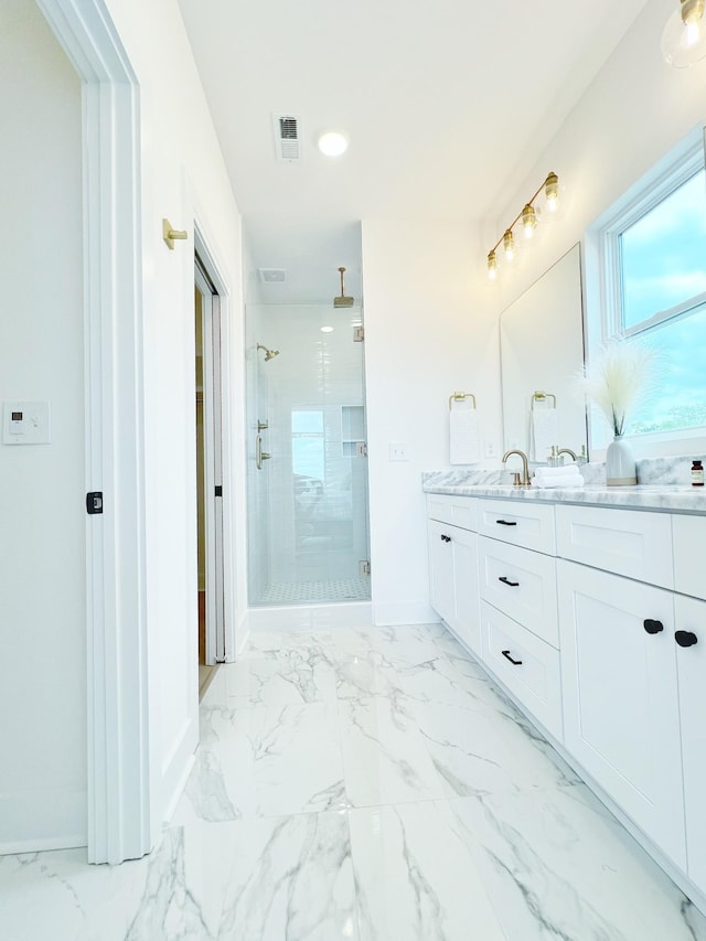 bathroom with vanity and a shower with door