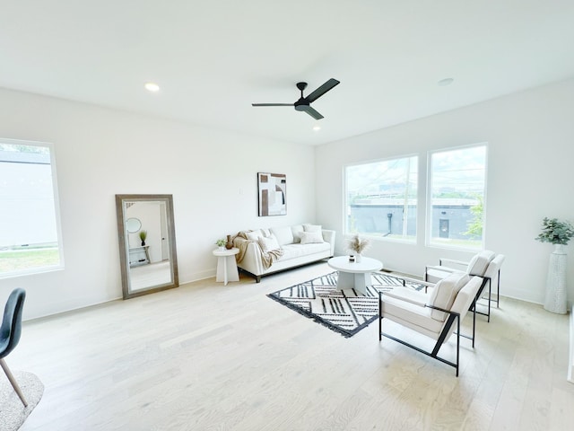 living room featuring light wood-type flooring and ceiling fan