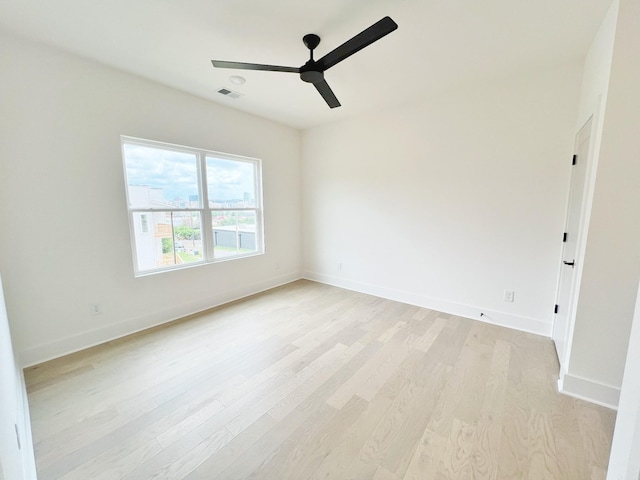 empty room with ceiling fan and light hardwood / wood-style floors