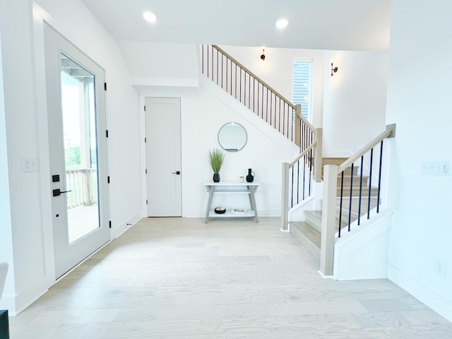 entrance foyer with light hardwood / wood-style floors and lofted ceiling